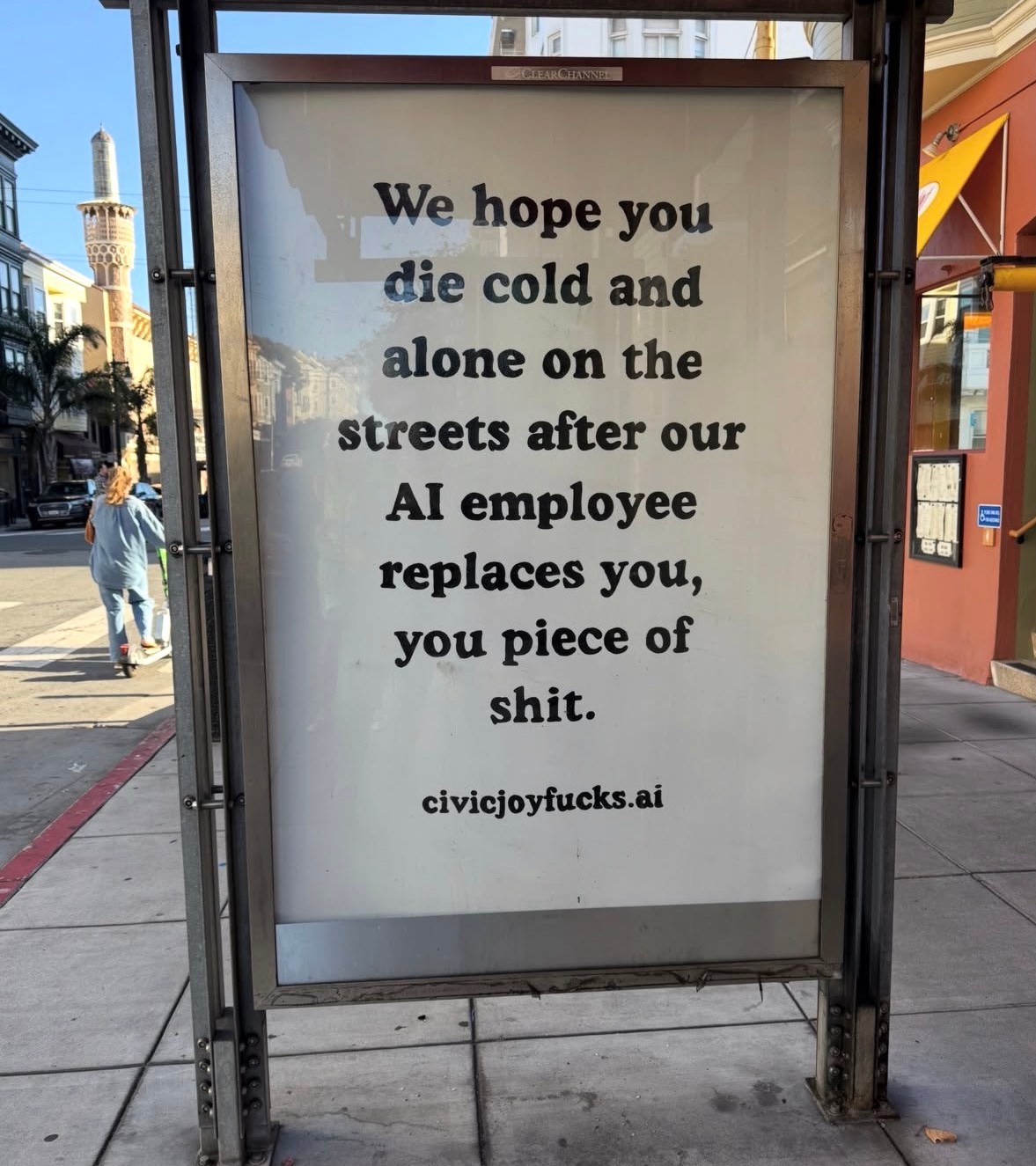 Protest sign in bus shelter criticizing AI job replacement with aggressive messaging