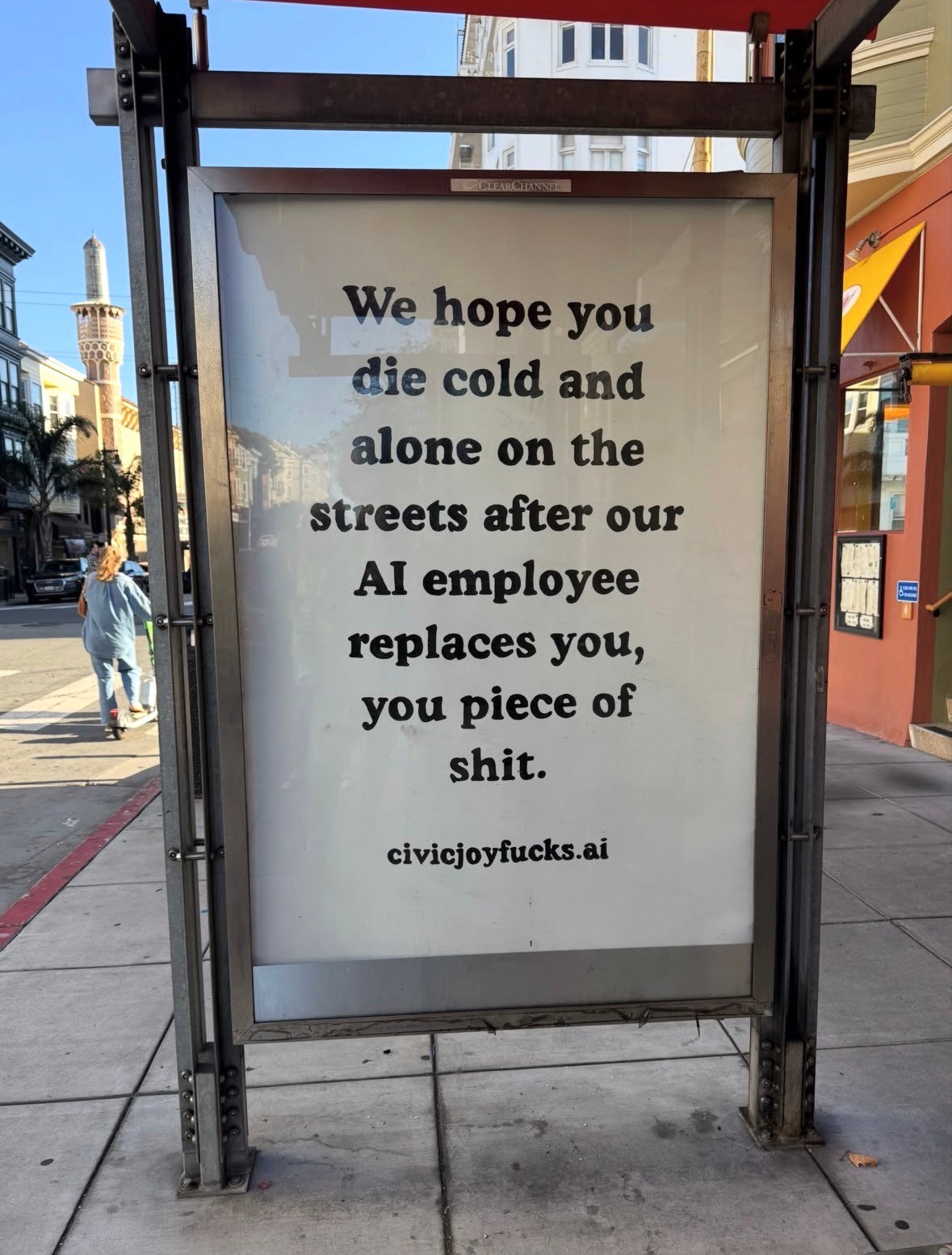 Protest sign in bus shelter criticizing AI job replacement with aggressive messaging